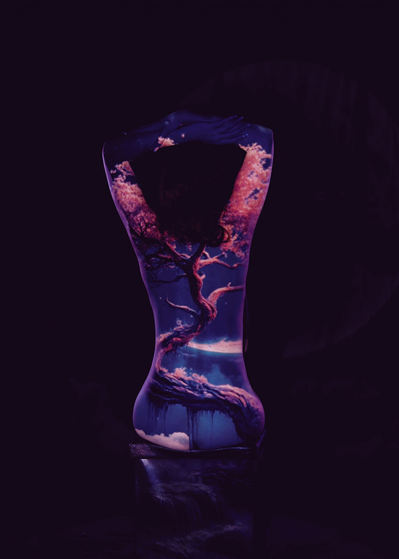 Silhouette of a person with a detailed projection of a twisted tree with pink blossoms and clouds on their back, set against a dark background