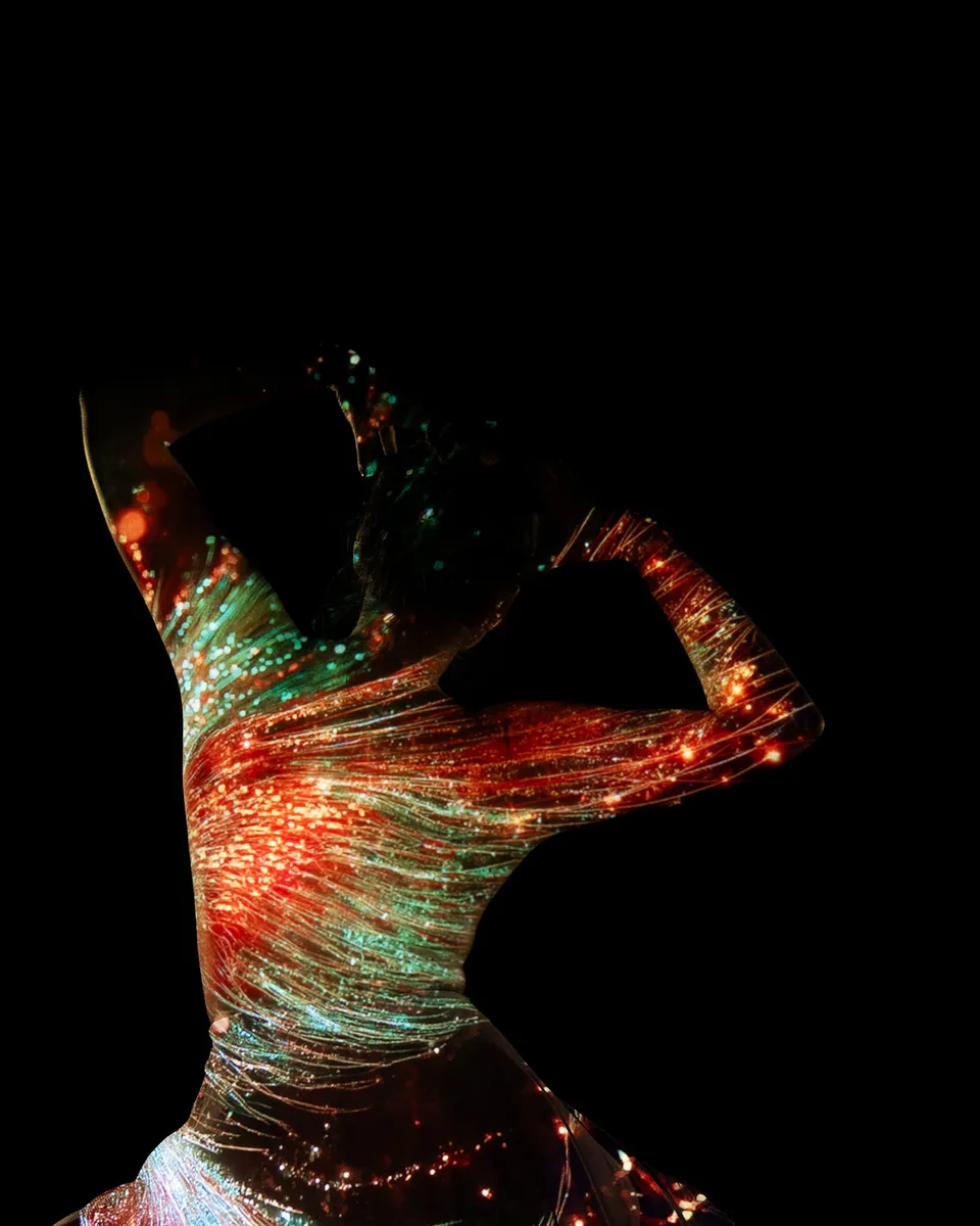 A figure in a fitted dress stands with arms raised and bent behind the head, illuminated by flowing red and teal light projections that create an abstract organic pattern.