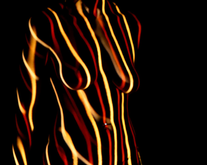 Human torso covered with curved, flowing stripes of yellow and red light against a black background