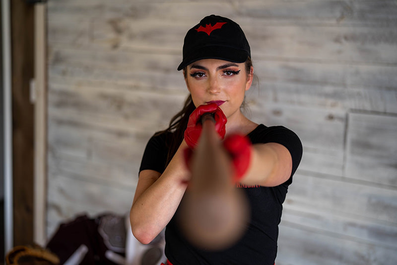 Cosplay focused woman aiming bat